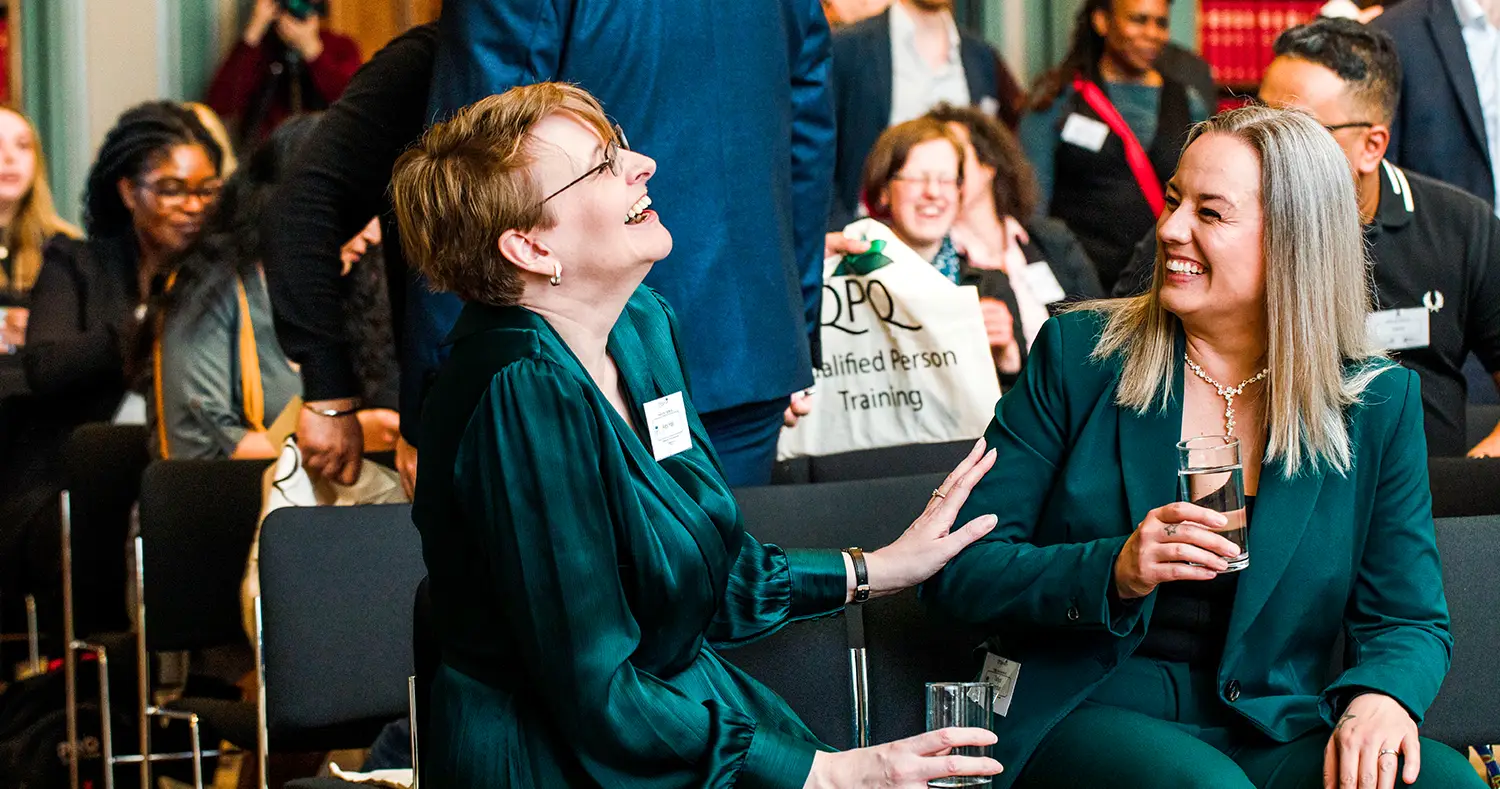 women laugh while at a marketing event